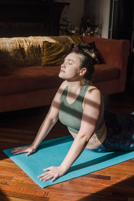 Smiling woman sitting on a yoga mat with her hands in a prayer pose